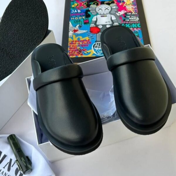 A pair of black rubber slide sandals with thick straps, displayed on a white background with a box and accessories.