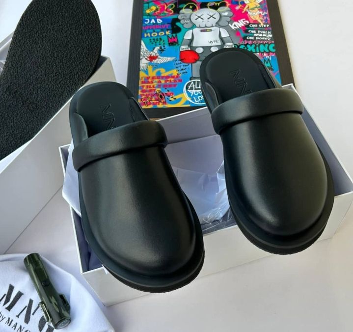 IMG-20260425-WA0016 A pair of black rubber slide sandals with thick straps, displayed on a white background with a box and accessories.