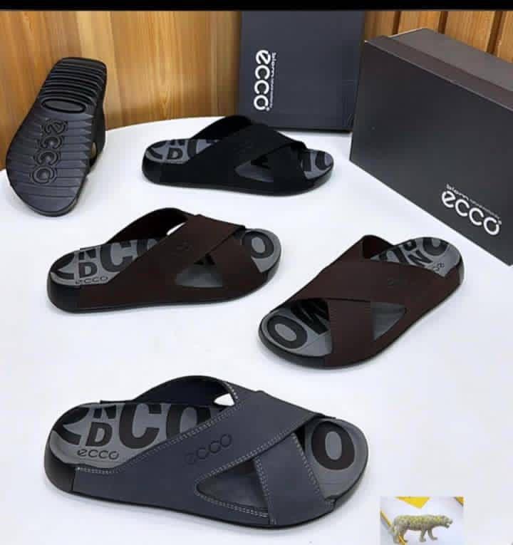 IMG-20260425-WA0018 ECCO men's slide sandals in black and brown, displayed with boxes and packaging on a white table.