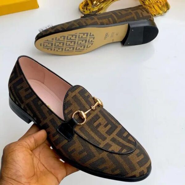 A pair of luxurious Fendi brown leather loafers with gold buckle, showcasing the shoe's intricate design and premium materials.