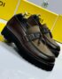 A pair of luxurious brown leather loafers with tassel details, set against a backdrop of yellow shoe boxes and a sleek alarm clock.