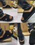 A close-up view of a person wearing black strap sandals with white stitching, showcasing the shoe from multiple angles.