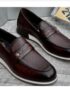 A pair of dark brown leather penny loafers with white soles, showcasing exceptional craftsmanship and style.