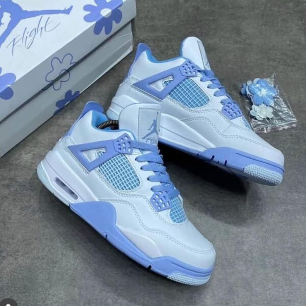 A pair of white and blue floral Air Jordan 4 Retro sneakers, accompanied by a matching box and accessories.