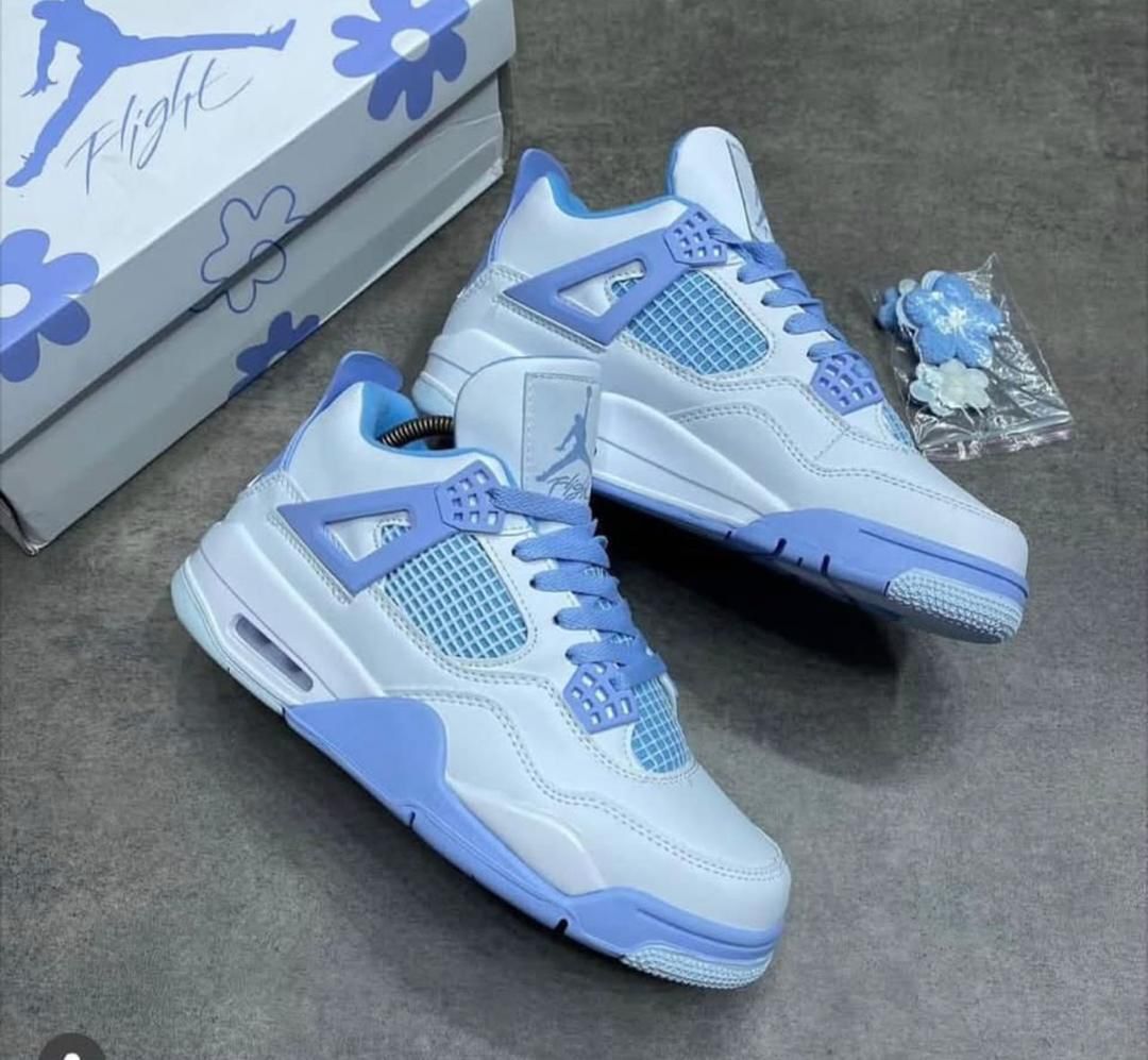 IMG-20260425-WA0041 A pair of white and blue floral Air Jordan 4 Retro sneakers, accompanied by a matching box and accessories.