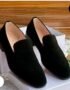 A pair of black suede loafers on a white shoe box, showcasing luxurious comfort and style.