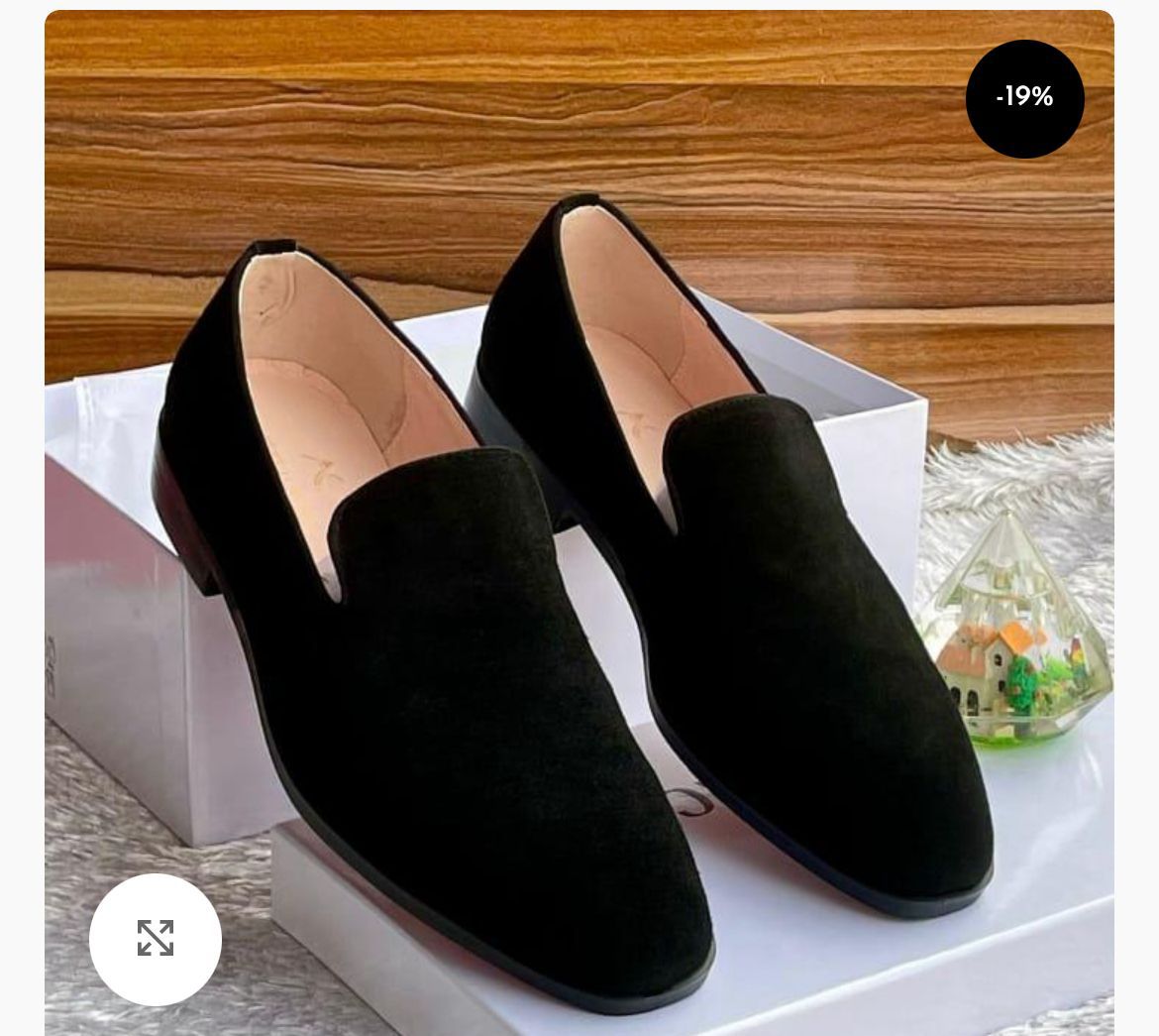 IMG-20260425-WA0047 A pair of black suede loafers on a white shoe box, showcasing luxurious comfort and style.