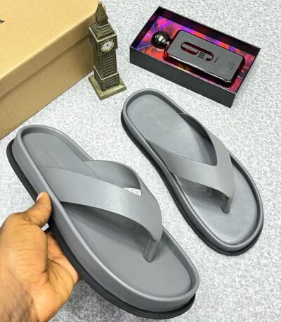 A pair of gray rubber flip flops, a symbol of luxury and comfort, displayed on a stylish background with a touch of elegance.