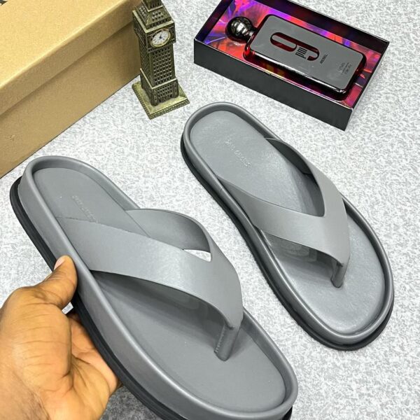 A pair of gray rubber flip flops, a symbol of luxury and comfort, displayed on a stylish background with a touch of elegance.