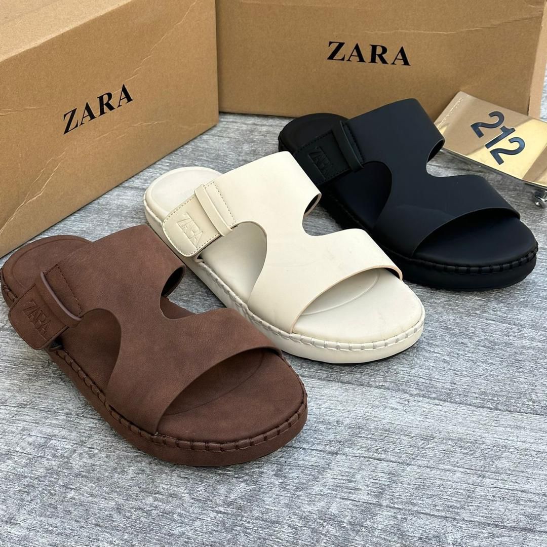 IMG-20260425-WA0060 A close-up view of Zara's two-strap buckle sandals in brown, beige, and black, showcasing the luxurious design and premium materials.