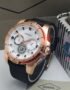 A rose gold Fossil watch with a black strap and white dial, displayed on a white surface with the Fossil logo and packaging in the background.