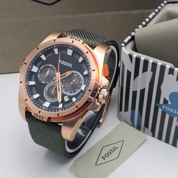 A luxurious Fossil watch with a rose gold case, black dial, and green strap, exuding high-end style and sophistication.