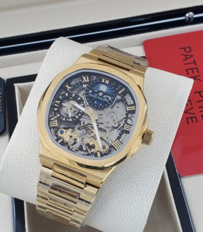 A gold Patek Philippe Geneve Skeleton watch on a white display, showcasing its intricate mechanical details and luxurious design.