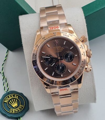 A luxurious rose gold Rolex Daytona watch with a brown dial, displayed on a white cushion in a green box, exuding opulence and refinement.