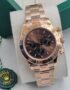 A luxurious rose gold Rolex Daytona watch with a brown dial, displayed on a white cushion in a green box, exuding opulence and refinement.