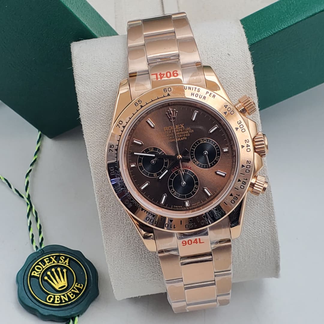IMG-20260612-WA0020 A luxurious rose gold Rolex Daytona watch with a brown dial, displayed on a white cushion in a green box, exuding opulence and refinement.