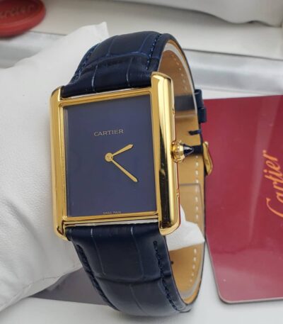A luxurious Cartier Tank watch with a navy blue dial and gold accents, paired with a sleek leather strap, exuding high-end style and sophistication.