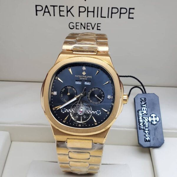A gold Patek Philippe Geneve men's watch with a black dial and date display, presented in a luxurious setting.