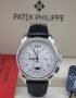 A luxurious Patek Philippe Geneve perpetual calendar watch with a black leather strap, showcased in its elegant packaging.