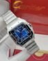 A sleek Cartier watch with a blue face and silver band, resting on a white glove with the Cartier box in the background.