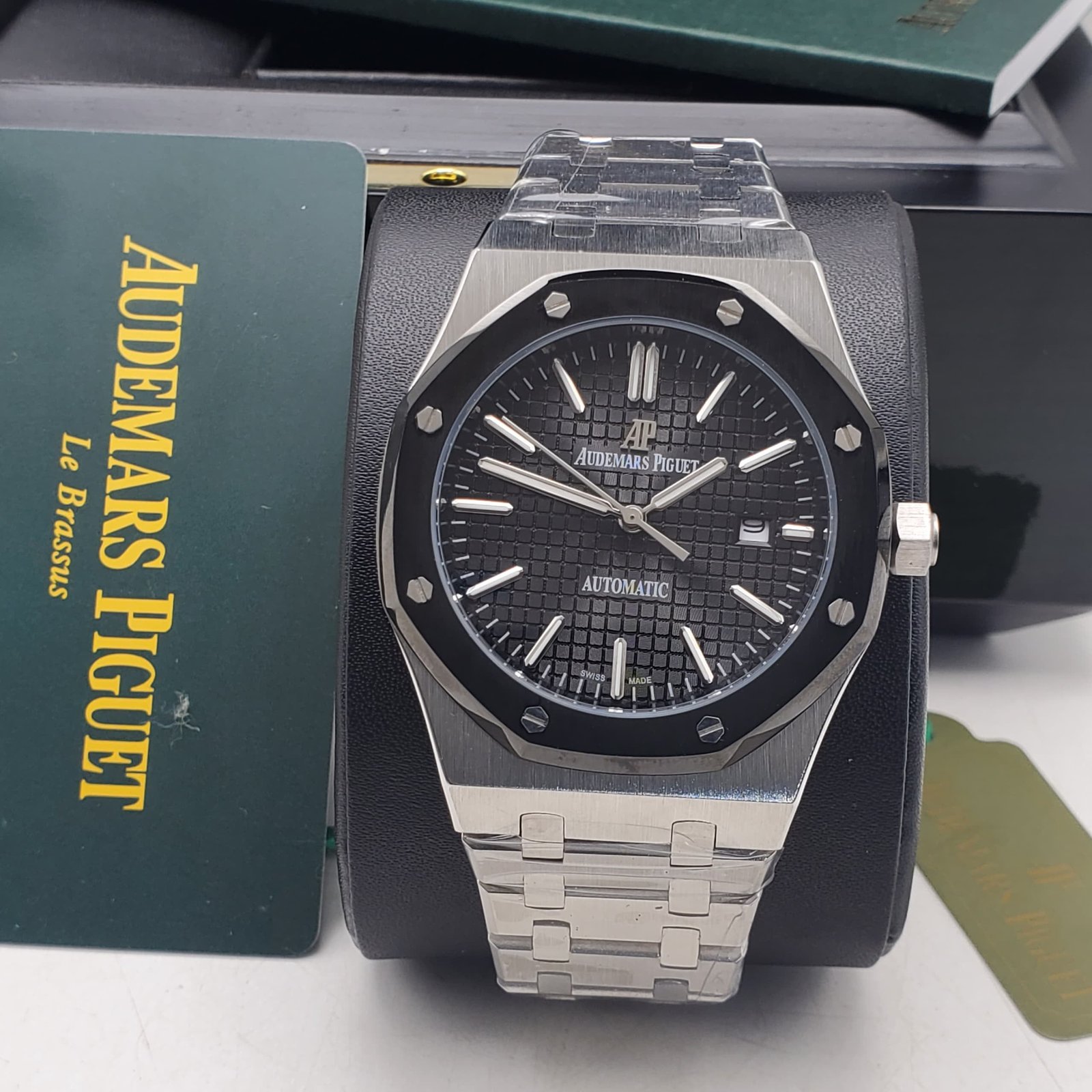 root Audemars Piguet luxury watch with black dial and stainless steel band, presented in its original box and packaging.