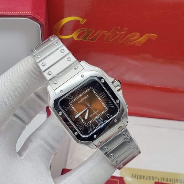A luxurious Cartier watch with a silver band and brown face, held by a gloved hand, showcasing high-end style and sophistication.