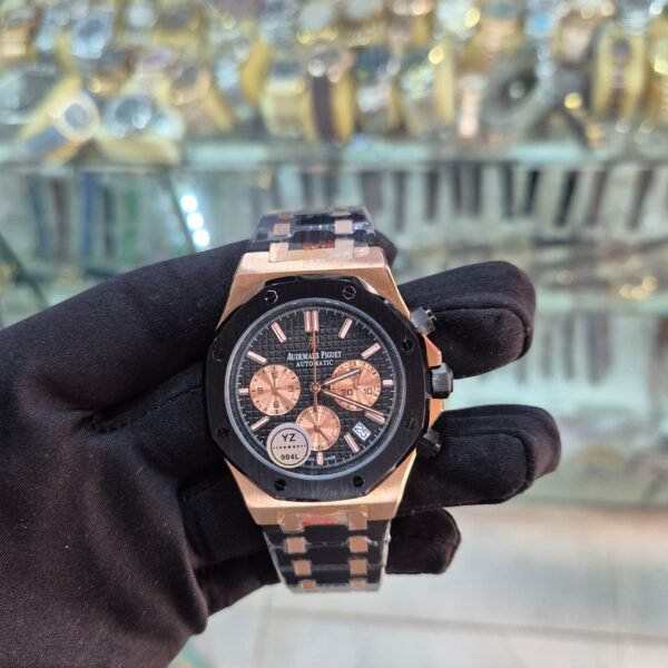A luxurious watch with a black and rose gold design, held by a gloved hand, showcasing its intricate details and precision.