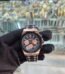 A luxurious watch with a black and rose gold design, held by a gloved hand, showcasing its intricate details and precision.