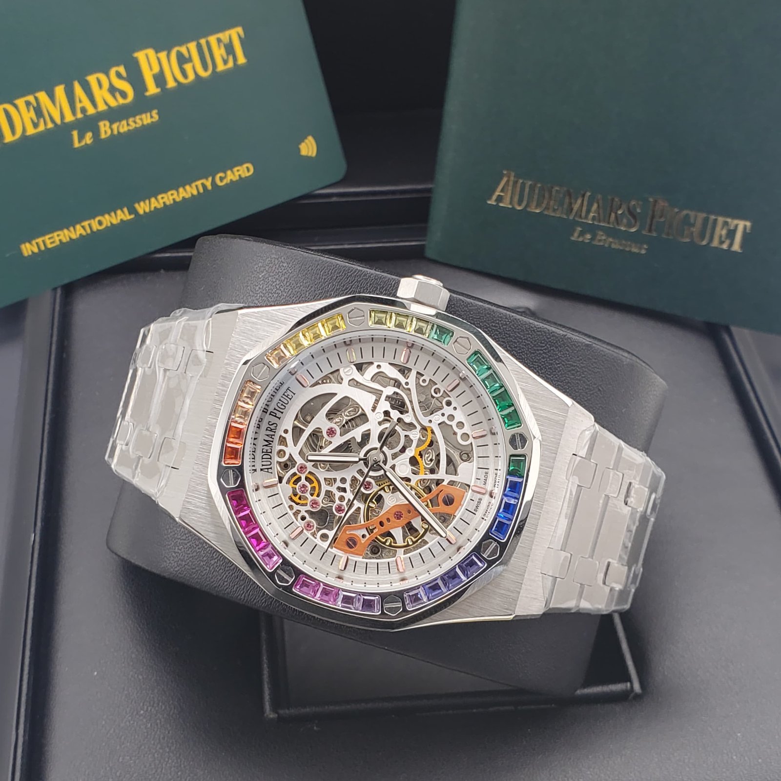 root Audemars Piguet luxury watch with a rainbow bezel and transparent case, showcasing its intricate mechanical movement.