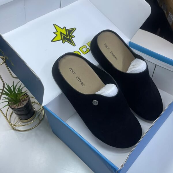 A pair of black loafers nestled in a white and blue shoe box, exuding luxury and comfort.